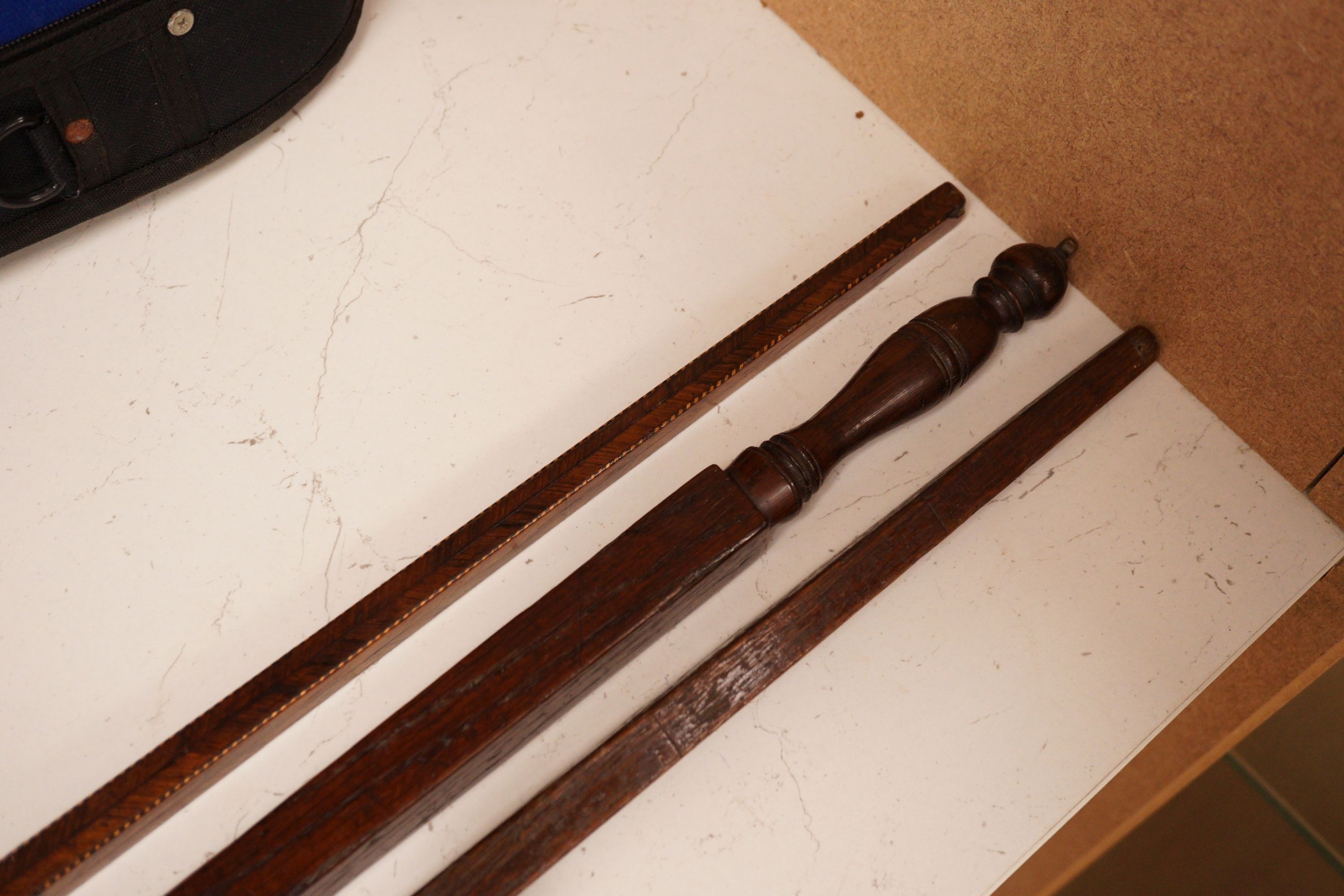 Three assorted 19th century treen measuring sticks to include a kingwood feather banded and marquetry inlaid measuring stick with stickware finial